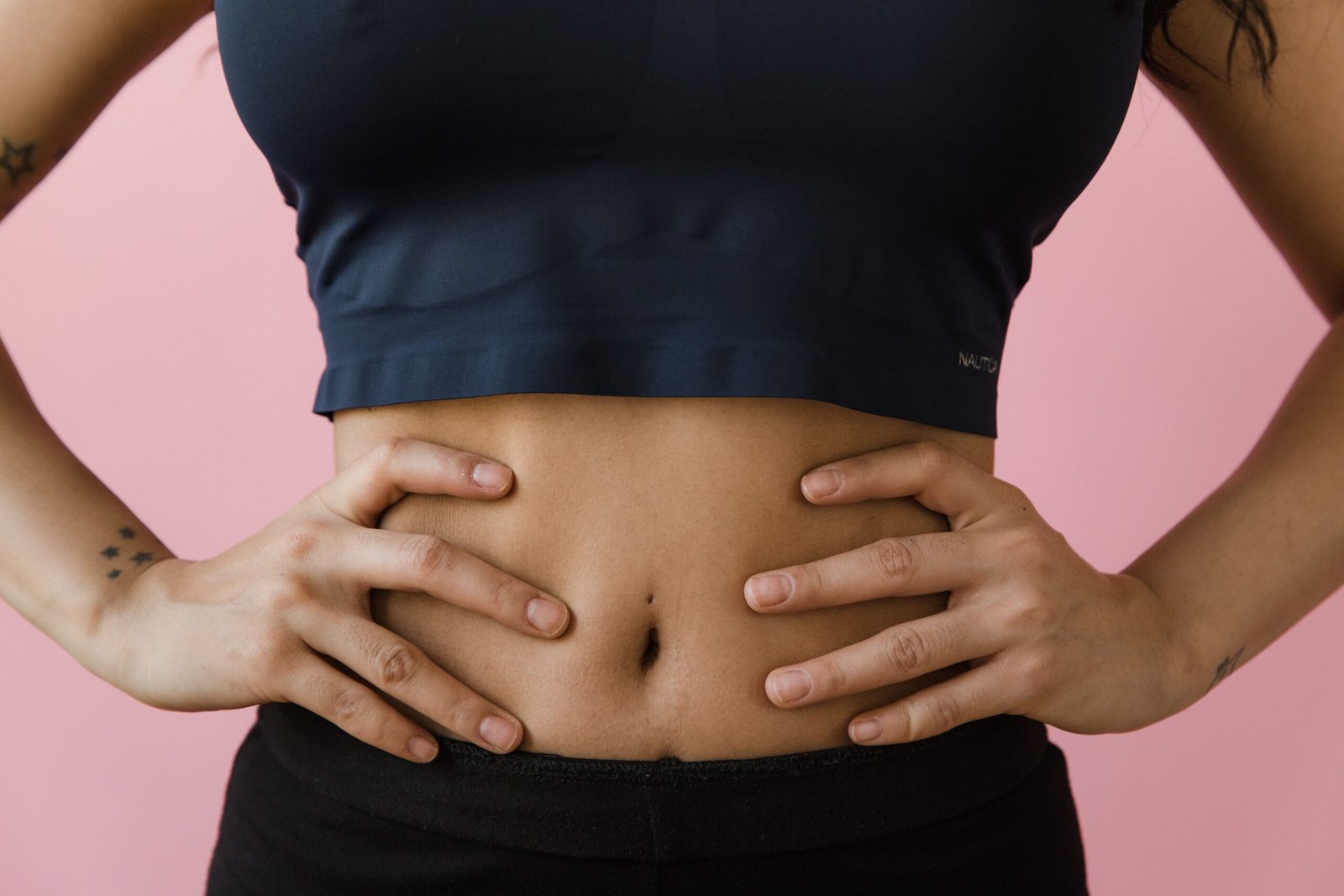 Woman holding abdomen representing digestive health and gut inflammation concerns