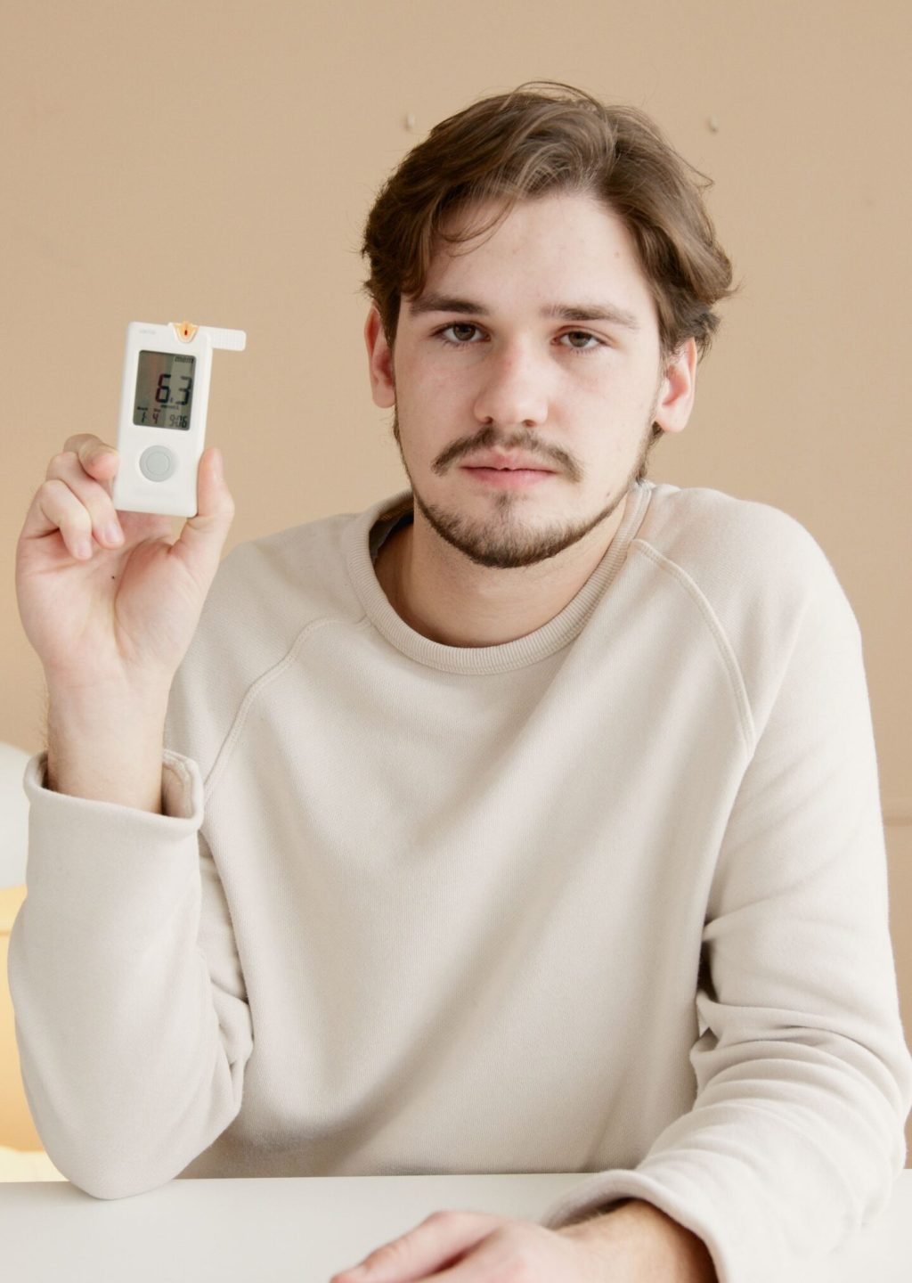 Individual holding a health monitoring device for wellness tracking